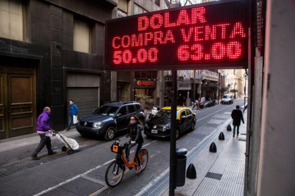 People walk past an exchange house where the currency exchange displayed is one U.S. dollar for 63 Argentine pesos, in Buenos Aires, Argentina, on Aug. 12, 2019. (Ricardo Ceppi/ Getty Images)