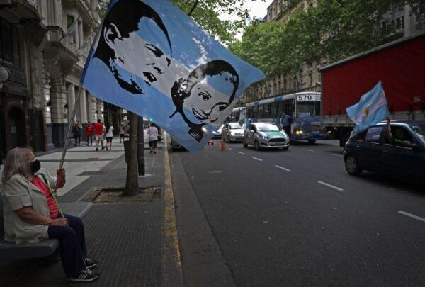 A demonstrator waves a flag with images of Argentina's late president Juan Domingo Peron and his wife Eva Duarte in Buenos Aires, Argentina, on Oct. 17, 2020. (Alejandro Pagni/AFP via Getty Images)
