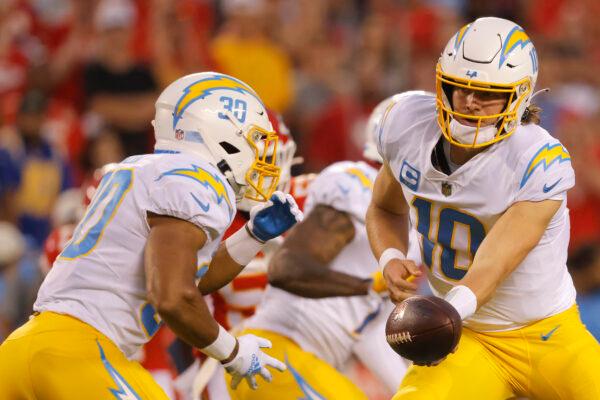Justin Herbert (10) of the Los Angeles Chargers hands the ball to Austin Ekeler (30) during the first quarter against the Kansas City Chiefs at Arrowhead Stadiumin Kansas City, on Sept. 15, 2022 . (David Eulitt/Getty Images)