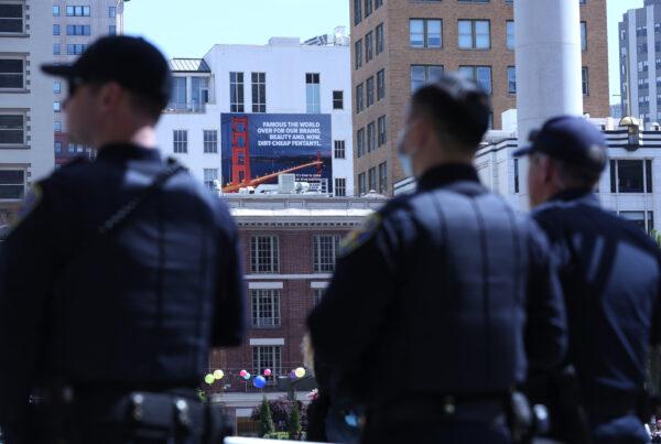 San Francisco police officers look on near a new controversial billboard that warns against fentanyl, in San Francisco on April 4, 2022. (Justin Sullivan/Getty Images)