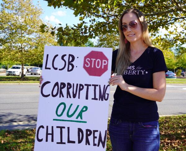 Loudoun County mother Megan Jenkins, a member of the parental rights group Moms for Liberty, holds a sign at a rally outside the Loudoun County Public Schools administration building in Ashburn, Va., on Sept. 13, 2022. (Terri Wu/The Epoch Times)