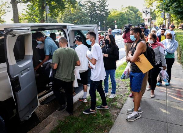 Illegal immigrants from Central and South America load into vans near the residence of Vice President Kamala Harris after being dropped off in Washington, D.C., on Sept. 15, 2022. (Kevin Dietsch/Getty Images)