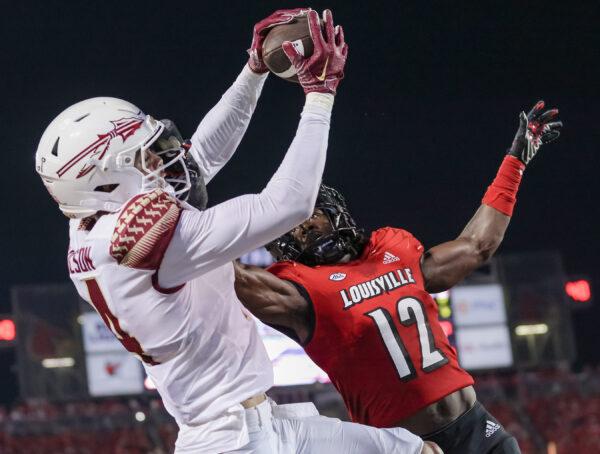 Johnny Wilson (14) of the Florida State Seminoles makes the game winning touchdown catch against Devaughn Mortimer (12) of the Louisville Cardinals during the second half at Cardinal Stadium in Louisville, Ky., on Sept. 16, 2022. (Michael Hickey/Getty Images)