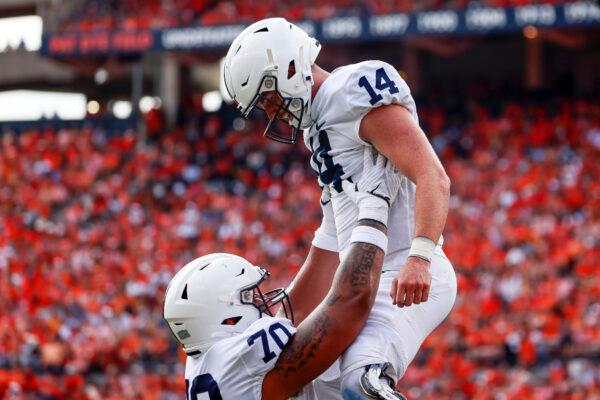 Penn State offensive lineman Juice Scruggs (70) celebrates with Penn State quarterback Sean Clifford (14) after he scored a touchdown against Auburn during the first half of an NCAA college football game in Auburn, Ala., on Sept. 17, 2022. (Butch Dill/AP Photo)