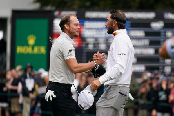 Max Homa, right, is greeted by Danny Willett, left, of England, on the 18th green of the Silverado Resort North Course after winning the Fortinet Championship PGA golf tournament in Napa, Calif., on Sept. 18, 2022. (Eric Risberg/AP Photo)