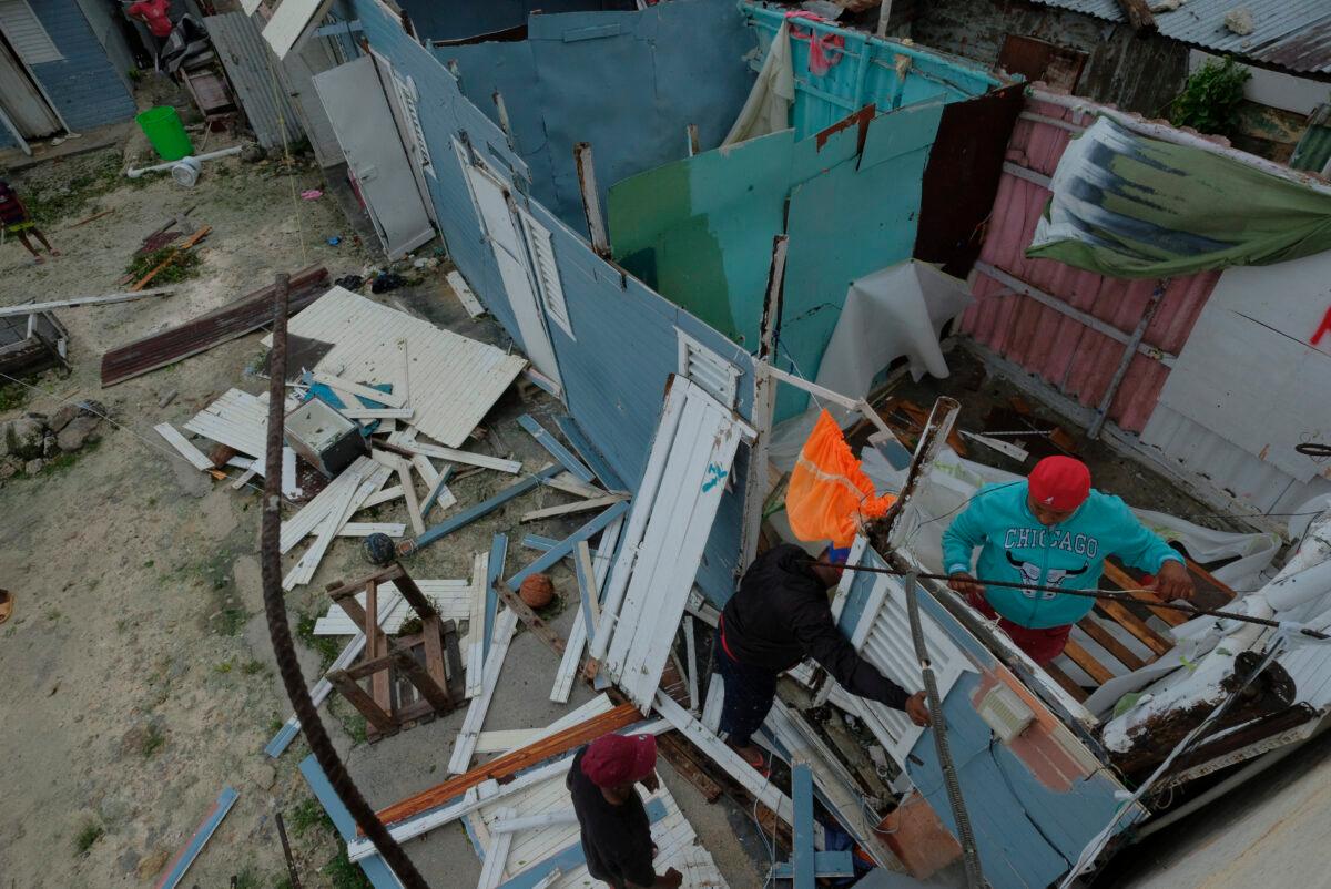 Residents replace a home's roof that was torn off by Hurricane Fiona in the low-income neighborhood of Kosovo in Veron de Punta Cana, Dominican Republic, on Sept. 19, 2022. (Ricardo Hernandez/AP Photo)