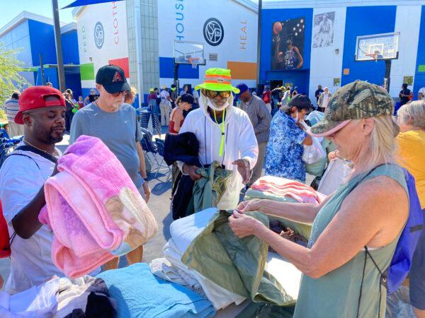 Homeless residents browse through donated clothing during a program run by the Chaplaincy for the Homeless, a charitable organization working with the homeless in The Zone on Sept. 18. (Allan Stein/The Epoch Times)