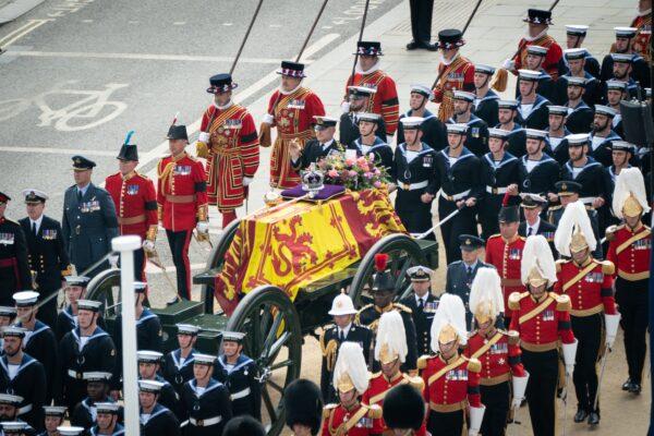 The State Gun Carriage carries the coffin of Queen Elizabeth II, draped in the Royal Standard with the Imperial State Crown and the Sovereign's orb and sceptre, as it leaves Westminster Abbey, on Sept. 19, 2022. (Stefan Rousseau/PA Media)