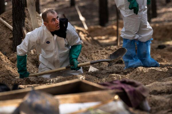 Rescue workers exhume bodies from unidentified makeshift graves at the Pishanske cemetery in Izium, Ukraine, on Sept. 19, 2022. (Paula Bronstein /Getty Images)