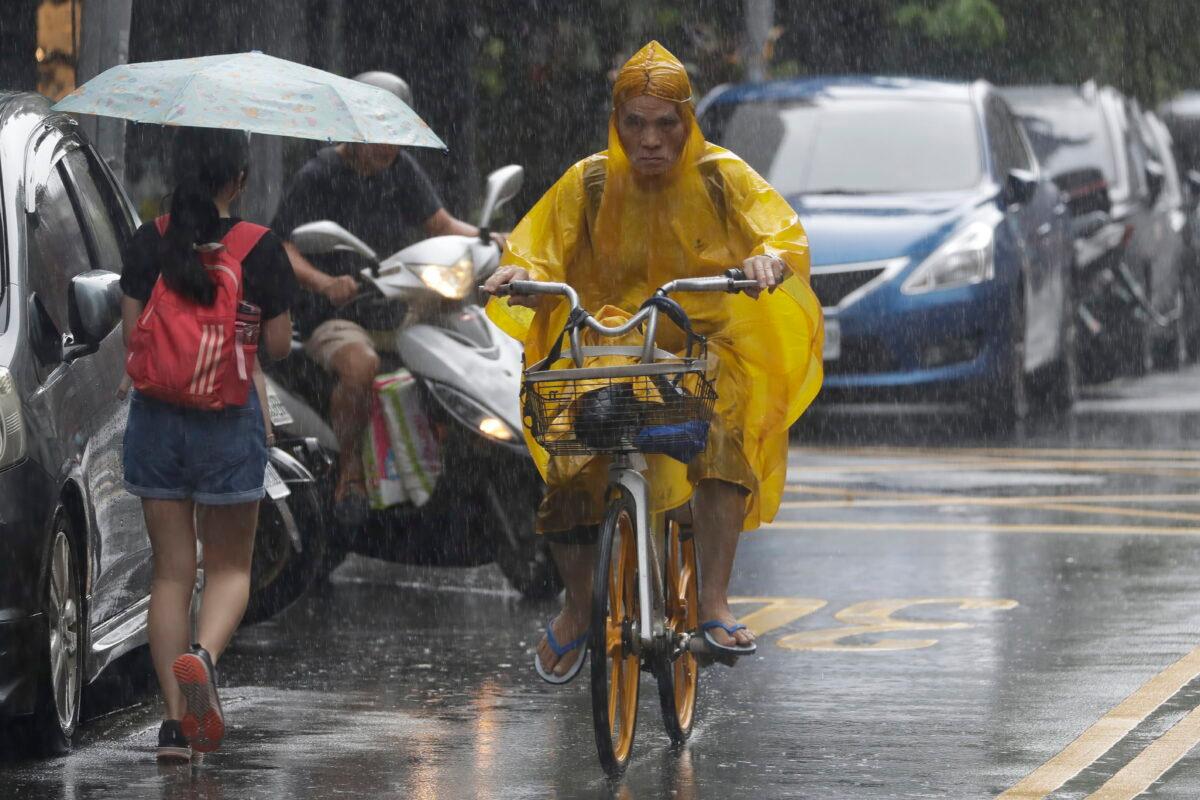 People make their ways in a rain ahead of the approaching Typhoon Hinnamnor in Taipei, Taiwan, on Sept. 3, 2022. (Chiang Ying-ying/AP Photo)