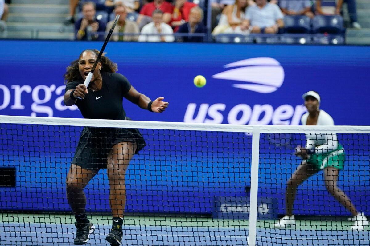 Serena Williams (L) returns a shot as Venus Williams of the United States looks on during their first-round doubles match against Lucie Hradecká and Linda Nosková of the Czech Republic at the U.S. Open tennis championships in New York on Sept. 1, 2022. (Frank Franklin II/AP Photo)