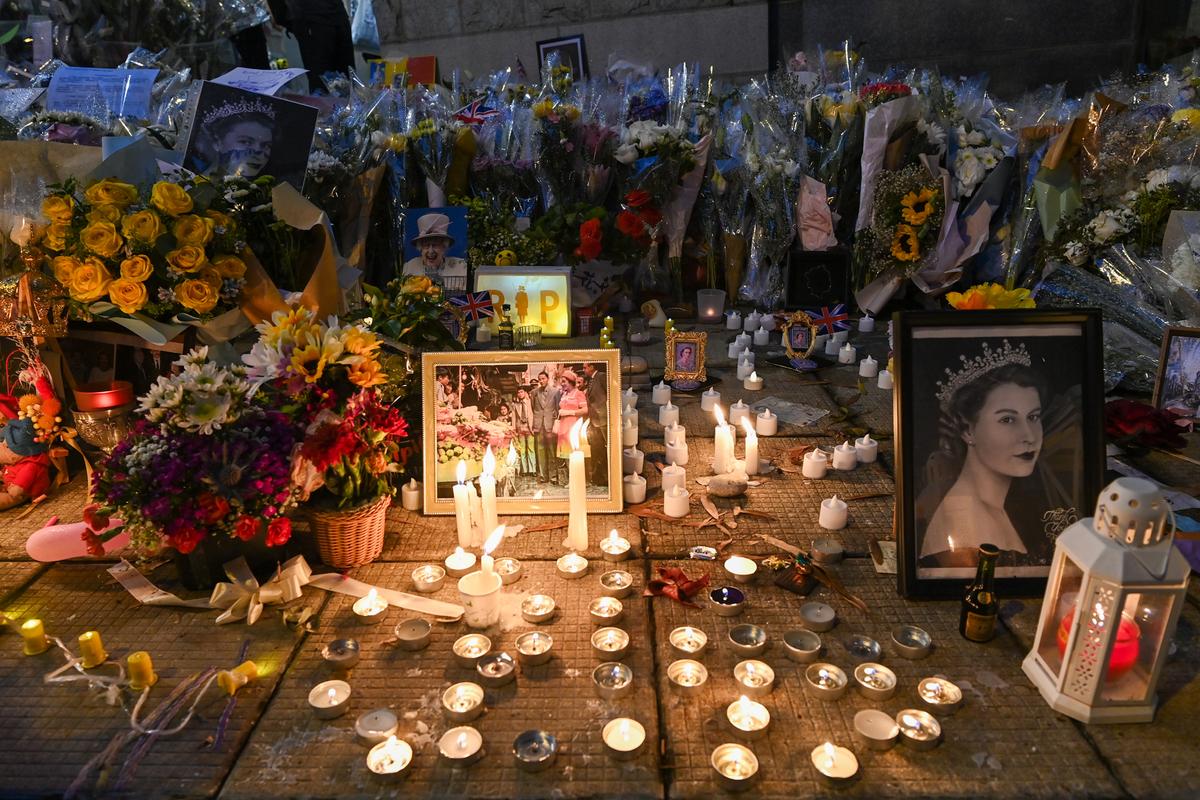 Members of the public mourn the passing of Queen Elizabeth II with flowers and candles outside the British Consulate General in Hong Kong on Sept. 19, 2022. (Sung Pi-lung/The Epoch Times)