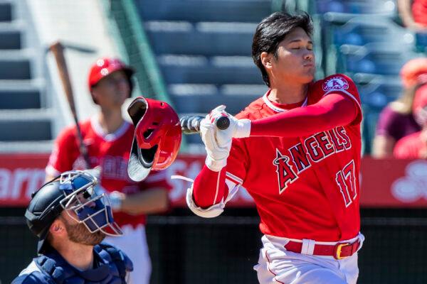 Los Angeles Angels designated hitter Shohei Ohtani, right, knocks off his helmet while fouling off a pitch next to Seattle Mariners catcher Curt Casali, left, during the fourth inning of a baseball game in Anaheim, Calif., on Sept. 19, 2022. (Alex Gallardo/AP Photo)