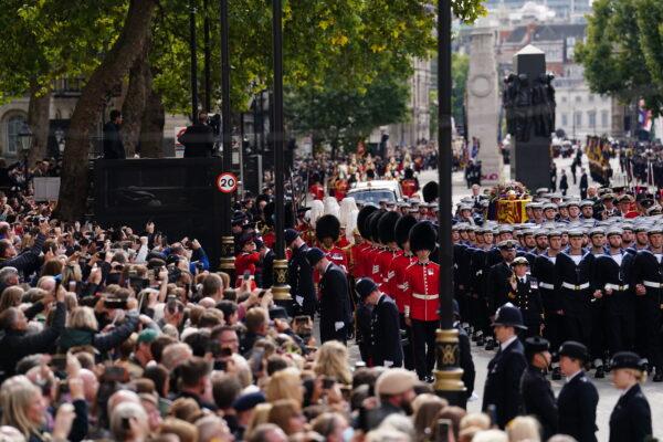 Crowds watch as the State Gun Carriage carries the coffin of Queen Elizabeth II in the Ceremonial Procession, following the State Funeral of Queen Elizabeth II at Westminster Abbey, London, on Sept. 19, 2022. (by David Davies - WPA Pool/Getty Images)