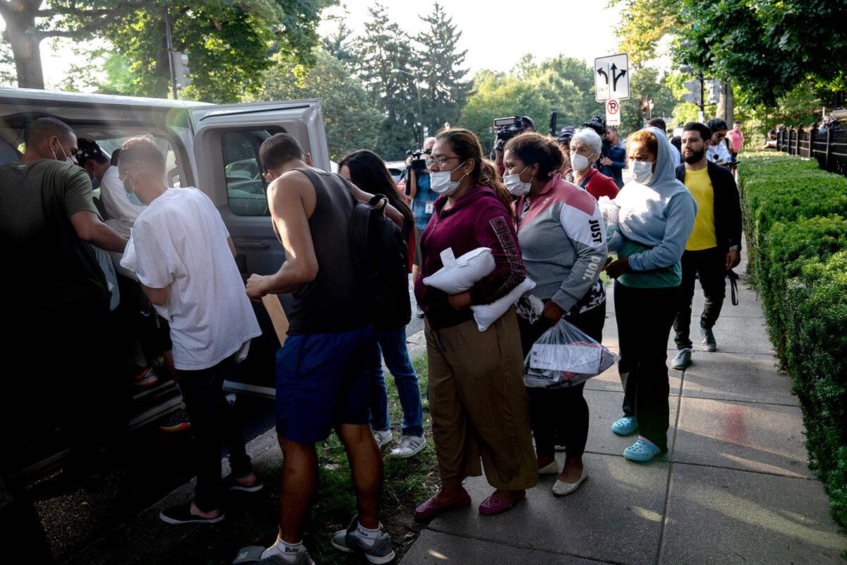 Illegal immigrants from Venezuela, who boarded a bus in Texas, wait to be transported to a local church by volunteers after being dropped off outside the residence of Vice President Kamala Harris, at the Naval Observatory in Washington, D.C., on Sept. 15, 2022. (Stefani Reynolds/AFP via Getty Images)