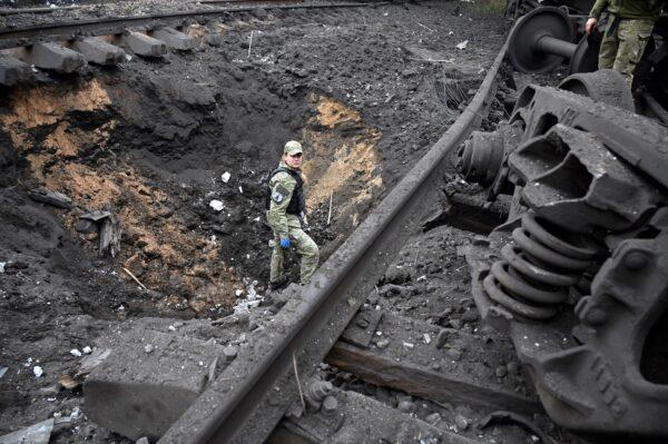 A forensic explosives expert examines a crater from a missile explosion at a freight railway station in Kharkiv on Sept. 21, 2022, amid Russia's military invasion of Ukraine. (Sergey Bobok/AFP via Getty Images)