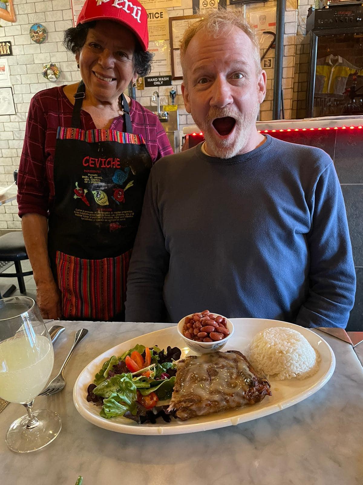 Nonna Rosa from Peru presents a diner with Costillas de Cerdo. (Courtesy of <a href="https://www.enotecamaria.com/">Jody Scaravella</a>)