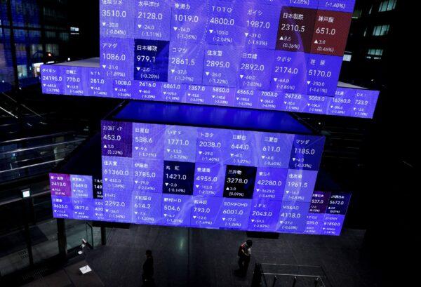 Visitors walk past Japan's Nikkei stock prices quotation board inside a conference hall in Tokyo, Japan, on Sept. 14, 2022. (Issei Kato/Reuters)