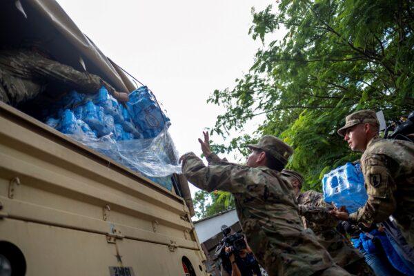  Members of the Puerto Rico National Guard distribute water in an affected community in the aftermath of Hurricane Fiona in Ponce, Puerto Rico, on Sept. 21, 2022. (Ricardo Arduengo/Reuters)