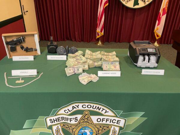 Items seized from a drug trafficking operation in Florida, including 30 firearms and $183,000 in cash. (Clay County Sheriff's Office)