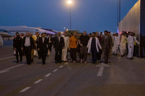 Prisoners of war (five British citizens, one Moroccan, one Swede, one Croat, and two Americans) are seen on the tarmac after arriving, following successful mediation efforts by Saudi Arabia's Crown Prince Mohammed bin Salman, from Russia to King Khalid International Airport, in Riyadh, Saudi Arabia, on Sept. 21, 2022. (Saudi Press Agency/Handout via Reuters)