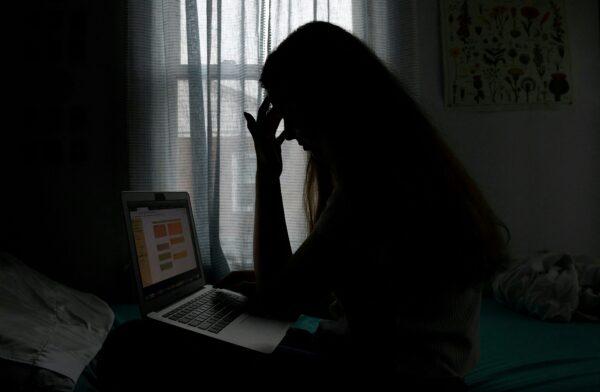 A teenager with a laptop in Arlington, Va., on June 11, 2021. (OLIVIER DOULIERY/AFP via Getty Images)