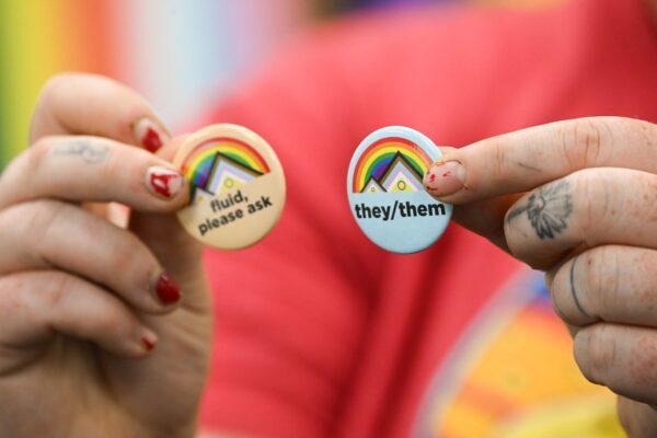 An LGBT activist holds pins about gender pronouns, on the University of Wyoming campus in Laramie, Wyoming, on Aug. 13, 2022. (Patrick Fallon/AFP via Getty Images)