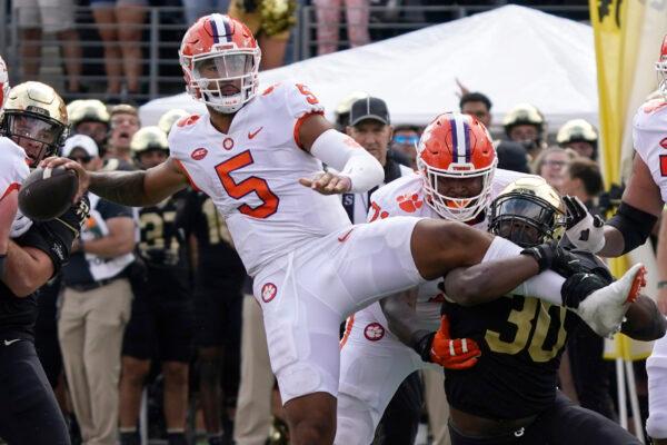 Clemson quarterback DJ Uiagalelei (5) looks to pass as Wake Forest defensive lineman Jasheen Davis (30) tries to tackle him during the second half of an NCAA college football game in Winston-Salem, N.C., on Sept. 24, 2022. (Chuck Burton/AP Photo)