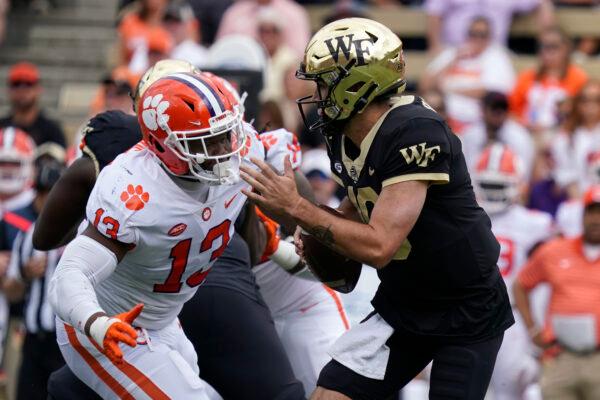 Wake Forest quarterback Sam Hartman (10) looks to pass as Clemson defensive tackle Tyler Davis (13) defends during the first half of an NCAA college football game in Winston-Salem, N.C., on Sept. 24, 2022. (Chuck Burton/AP Photo)