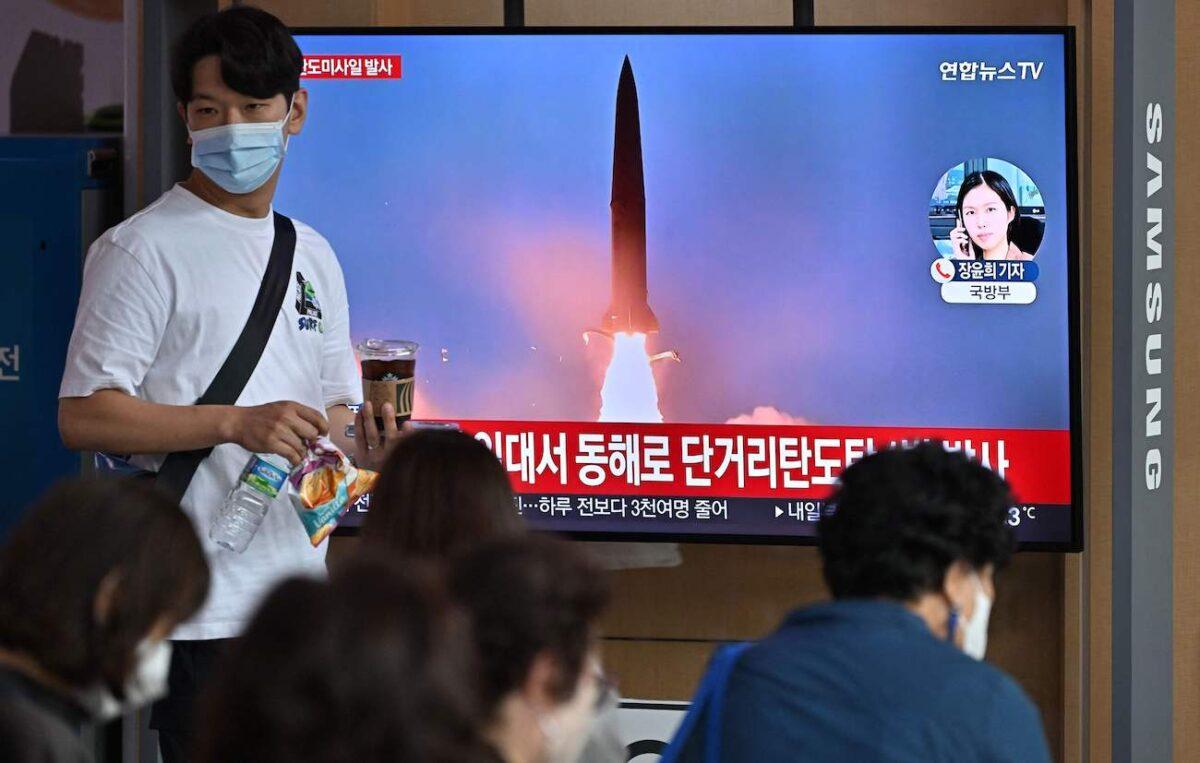 People watch a television screen showing a news broadcast with file footage of a North Korean missile test at a railway station in Seoul, South Korea, on Sept. 25, 2022. (Jung Yeon-je/AFP via Getty Images)