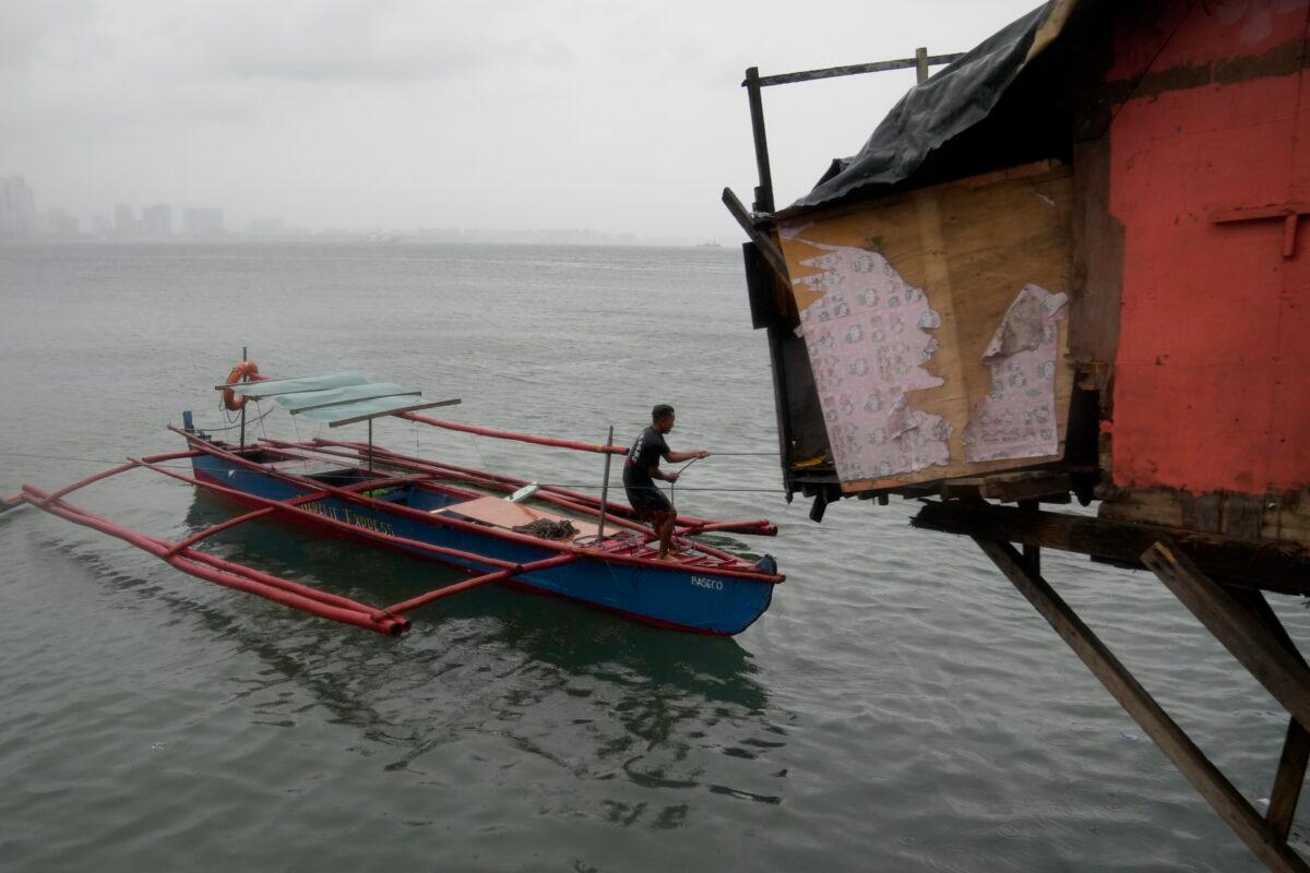 A resident secures his boat as Typhoon Noru approaches the seaside slum district of Tondo in Manila, Philippines, on Sept. 25, 2022. (Aaron Favila/AP Photo)