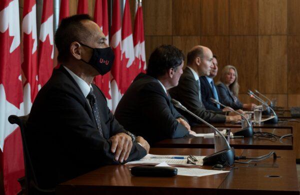 Deputy Chief Public Health Officer Howard Njoo (L) listens to ministers speak during a news conference announcing an end to COVID-19 requirements at the border in Ottawa on Sept. 26, 2022. (The Canadian Press/Adrian Wyld)