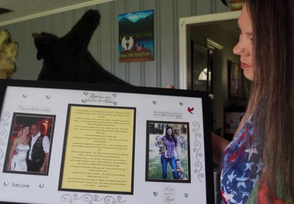 Nikki Jones holds a copy of her wedding vows framed alongside photos from happy days at her home in Plant City, Fla., on Sept. 20, 2022. (Jann Falkenstern/The Epoch Times)