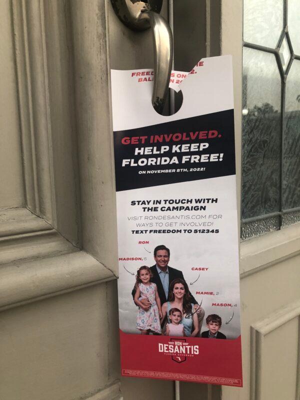 Volunteers with the reelection campaign for Florida Gov. Ron DeSantis leave these door-hanger ads, showing him with his wife and children, at the homes of voters. (Nanette Holt/The Epoch Times)