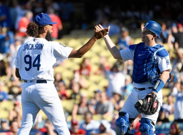 Andre Jackson (94) of the Los Angeles Dodgers celebrates the win over the St. Louis Cardinals with Will Smith (16) at Dodger Stadium in Los Angeles, on Sept. 25, 2022. (Kevork Djansezian/Getty Images)
