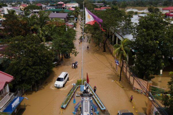 Residents pass by a flooded road from Typhoon Noru in San Miguel, Bulacan Province, Philippines, on Sept. 26, 2022. (Aaron Favila/AP Photo)