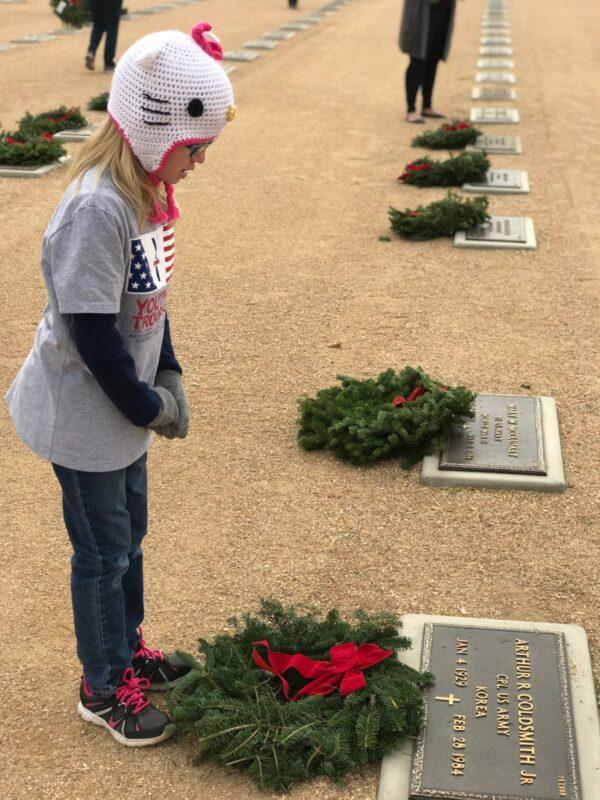 Youth for Troops volunteer Alexandra Ceren stands before the grave of Korean War veteran Arthur R. Coldsmith Jr. at the National Memorial Cemetery of Arizona in December 2019. (Courtesy of Youth for Troops)