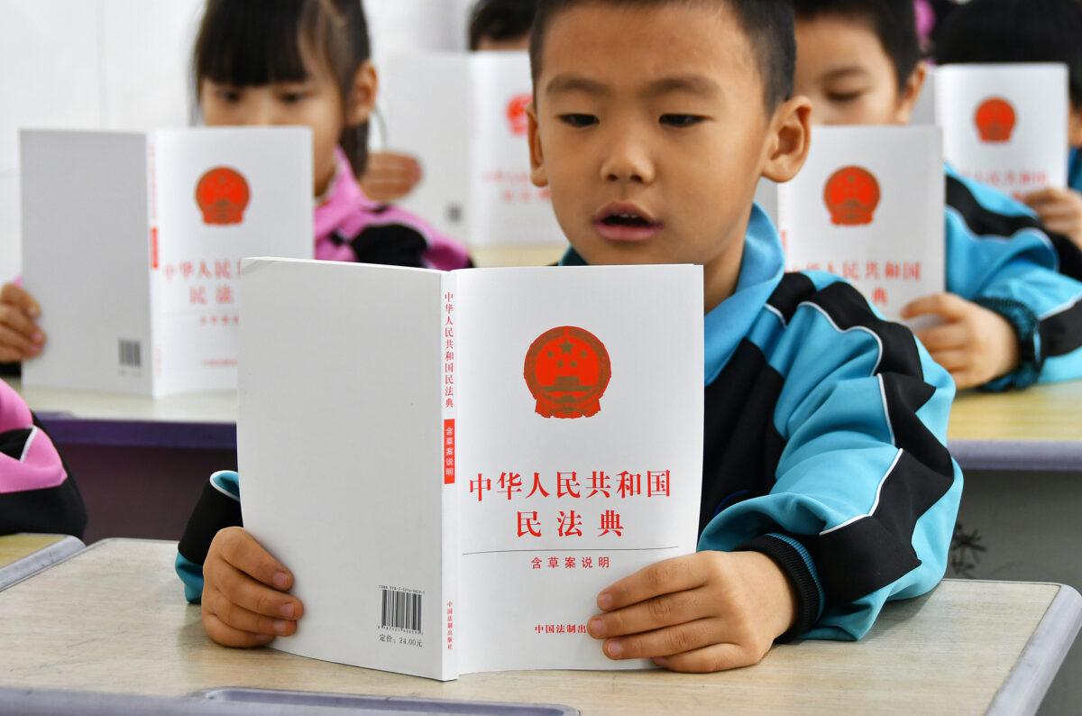 Pupils read the Civil Code in Yantai City, Shandong Province, China, on Nov. 30, 2020. (Costfoto/Future Publishing via Getty Images)