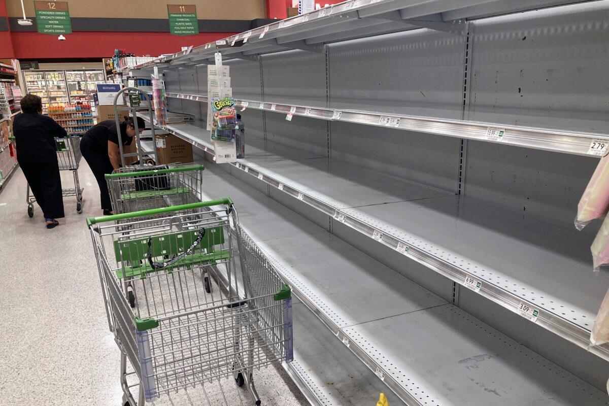 As Hurricane Ian approaches Florida, shopping carts are left abandoned next to empty shelves that stock bottled water at a supermarket in Orlando, Fla., on Sept. 26, 2022. (John Raoux/AP Photo)