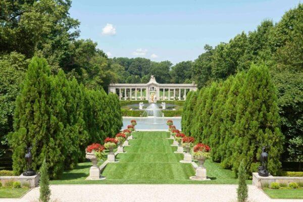 Viewed from the second floor of the mansion, the "Long Walk” is a terraced lawn lined with pedestals that leads from fountain basins to the Reflection Pond and colonnade beyond. Each step of the walkway has flower-filled goblets at each end. (J.H.Smith/Cartiophotos)