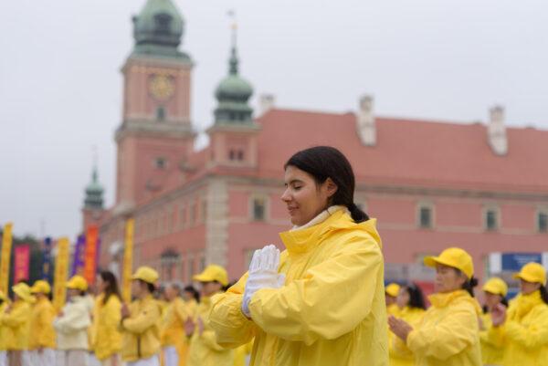 Falun Dafa practitioners meditate after a march through the center of Warsaw, Poland, on Sept. 9, 2022. (Mihut Savu/The Epoch Times)