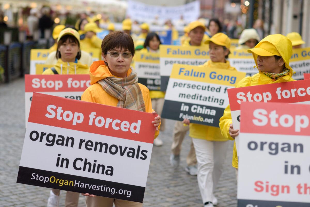 Falun Dafa practitioners carry banners to raise awareness about organ harvesting in China during a march through the center of Warsaw, Poland, on Sept. 9, 2022. (Mihut Savu/The Epoch Times)
