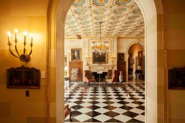 Carrère & Hastings was one of the first architectural firms of the age to offer a specialized interior design staff that mastered French neoclassical and renaissance styles. The main entrance hall, with its coffered ceiling, gilded trim, and marble mantel surrounding the fireplace, is seen through the arched doorway. (Courtesy of J.H.Smith/Cartiophotos)