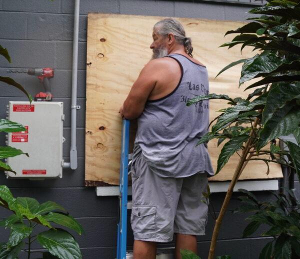 New Florida resident, Ross Davis boards up his windows in preparation for Hurricane Ian, on Sept. 27, 2022. (Jann Falkenstern/The Epoch Times)