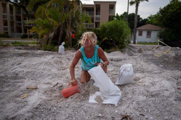 Barbara Schueler fills sandbags in a vacant lot in preparation for Hurricane Ian in St. Pete Beach, Fla., on Sept. 26, 2022. (Ricardo Arduengo/AFP via Getty Images)