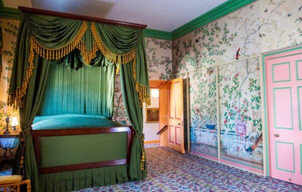 Queen Victoria had her own room, less grand than the public rooms. A floral tapestry and hand-painted wallpaper features idyllic nature with birds, flora, and fauna in soft colors. The bed and chairs are in the Regency style characterized by plain wood veneers rather than extensive carving. (Brighton & Hove Museums)