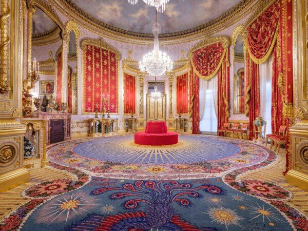 The saloon is the grandest room of the palace. Robert Jones, the interior decorator of the pavilion, designed the room. The central dome is supported by a cast-iron frame, and the blue woven carpet displays a peacock, reflecting the light blue domed ceiling. The red and gold silk wall panels and curtains are inspired by the French decorating style of the Napoleonic area. The wall is covered by silver, instead of gold, leaf. Chinese vases are placed everywhere in the space. The carpet is designed with woven sunflowers, dragons, and lotus leaves. (Brighton & Hove Museums)