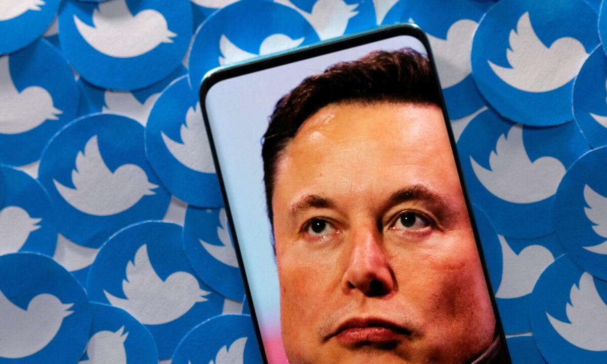 Elon Musk on a smartphone placed on printed Twitter logos, on April 28, 2022. (Dado Ruvic/Illustration/Reuters)