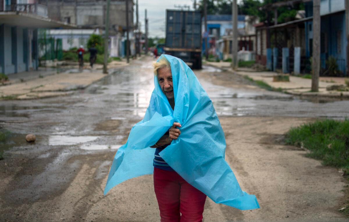 A resident uses plastic as protection from the rain in Batabano, Cuba, on Sept. 26, 2022. (Ramon Espinosa/AP Photo)