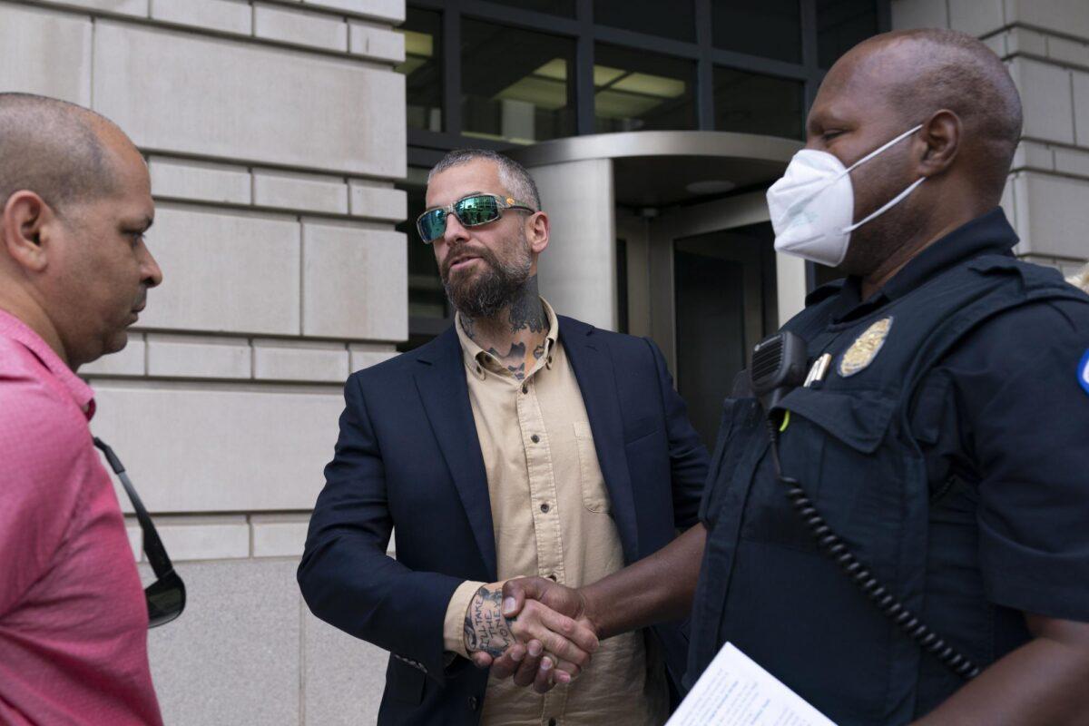 Former D.C. Metropolitan Police Officer Michael Fanone, center, shakes hands with a Capitol Police officer as Capitol Police Sgt. Aquilino Gonell, left, stands by outside the federal courthouse in Washington on Sept. 27, 2022. (Jose Luis Magana/AP Photo)